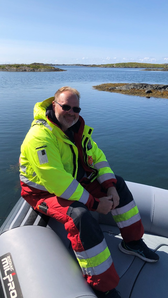 Mann i gul refleksvest ute på havet